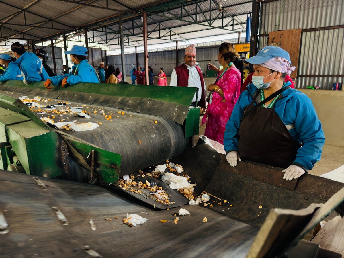 about-03 Workers sorting waste in a recycling facility in Butwal, Nepal, showcasing environmental sustainability efforts.