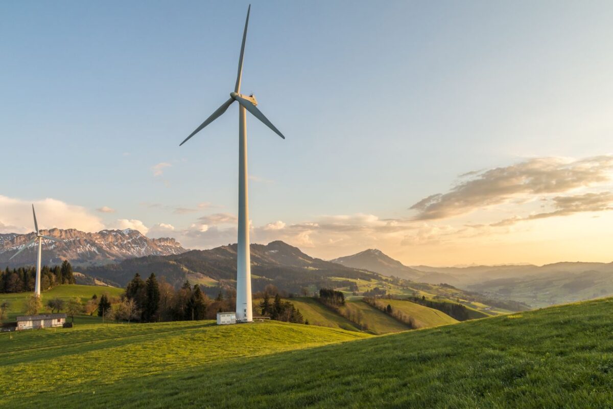 about-02 Peaceful countryside with wind turbines during sunset, showcasing sustainable energy.